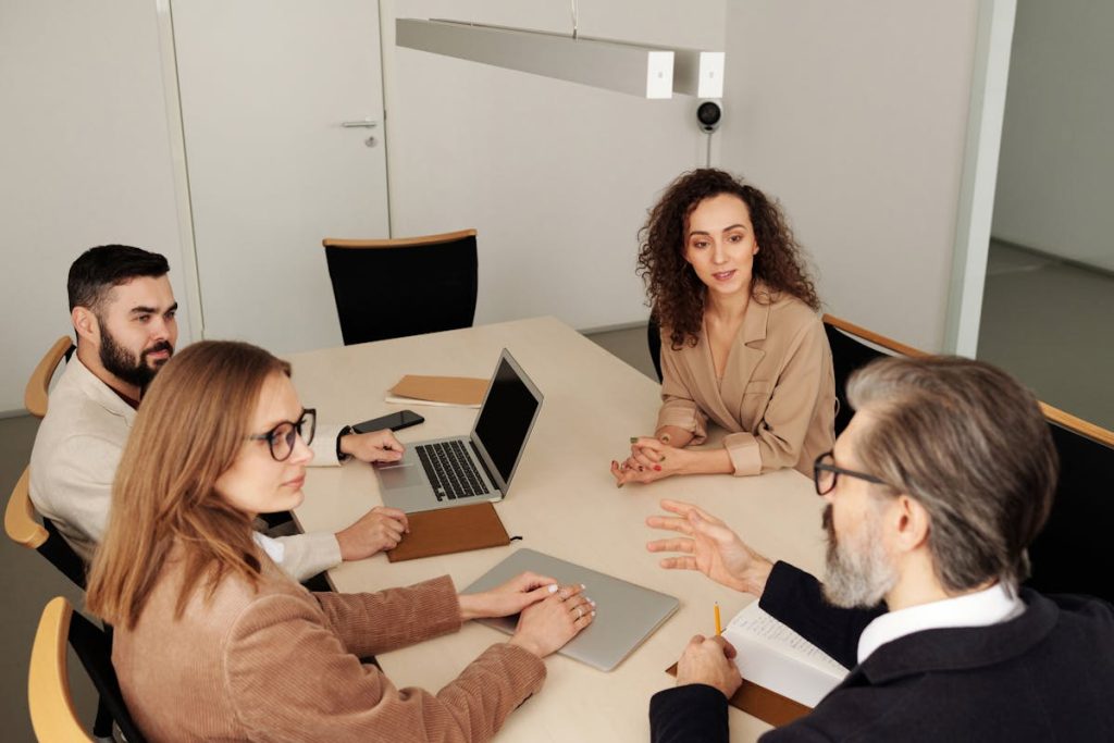 Four colleagues in discussion around a meeting table