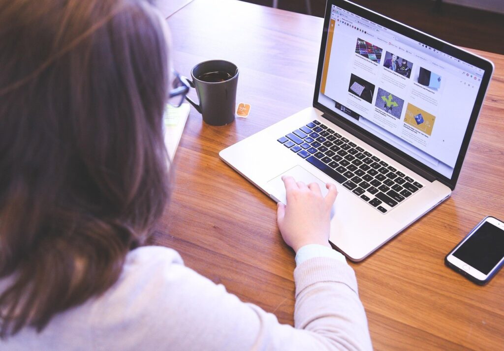 femme entrepreneuse smartphone reseaux sociaux Femme entrepreneure consultant son smartphone à son bureau, applications de réseaux sociaux à l'écran
