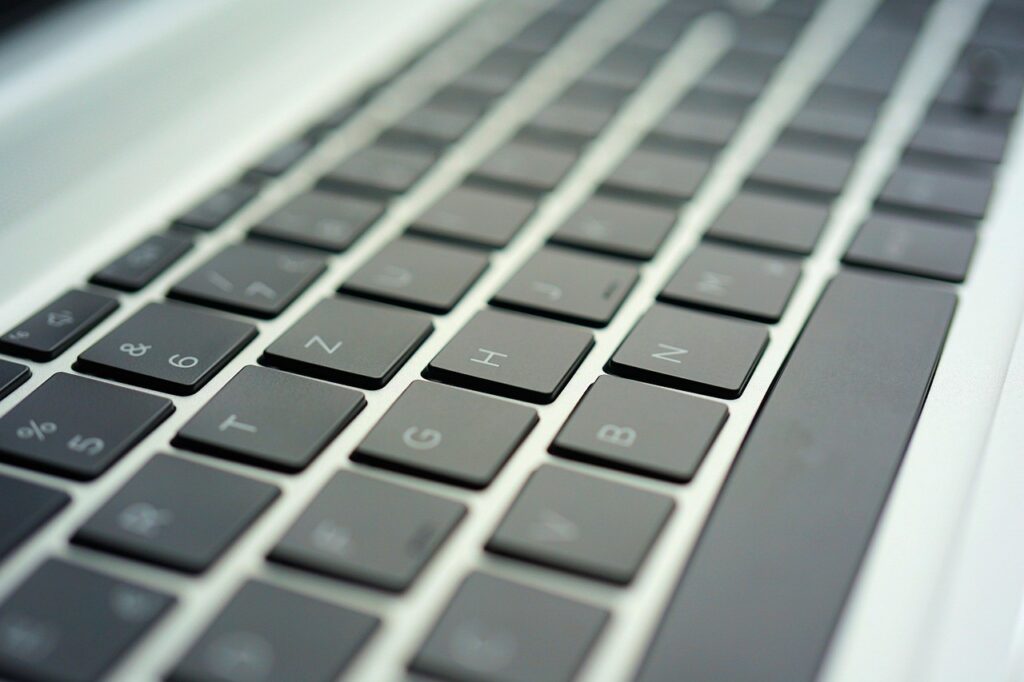 clavier frappe requete recherche Gros plan sur un clavier d'ordinateur portable, mains en train de taper une recherche