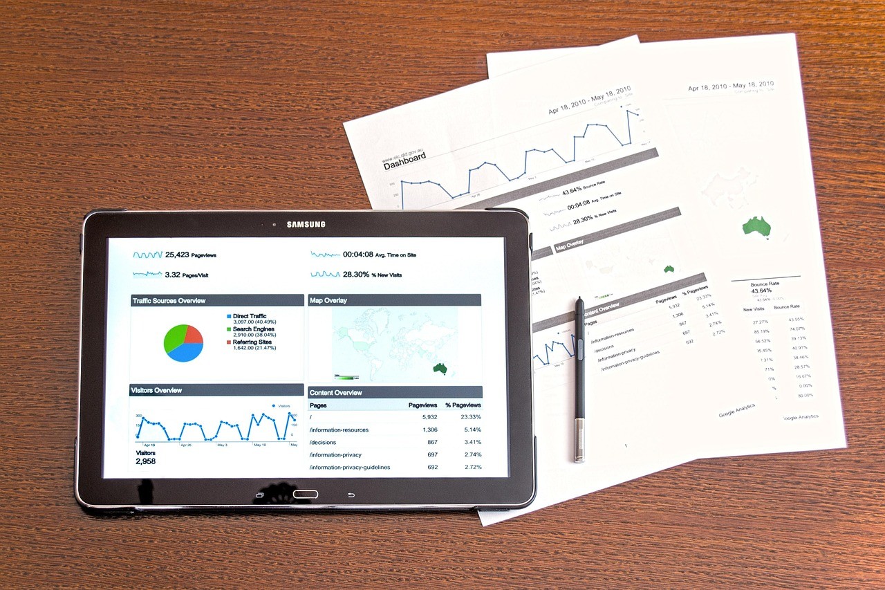 Tablet and printed reports on an office desk during a marketing campaign review